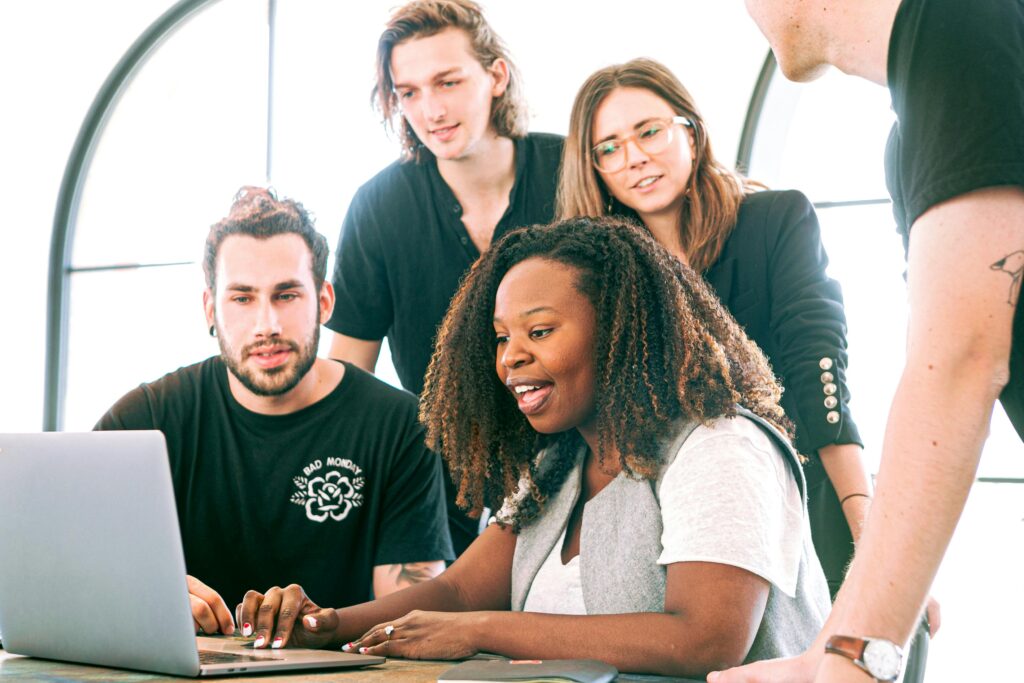 pexels-photo-3153198-3153198 A diverse group of young professionals collaborating around a laptop in a modern office setting. Perfect for business or tech concepts.