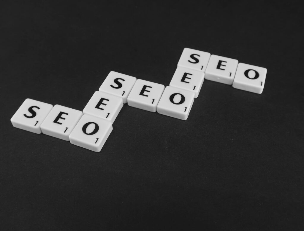 pexels-photo-7119258-7119258 SEO spelled with Scrabble tiles on a black surface, representing search engine optimization concepts.